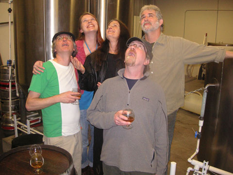 Band members posing together at a brewery looking up